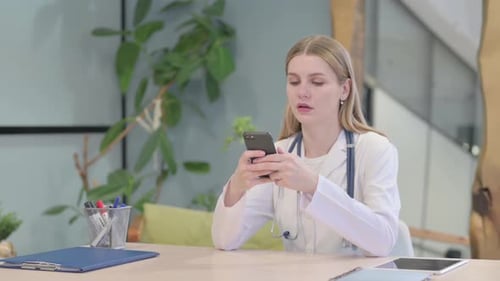 Young Doctor Browsing Smartphone in Clinic