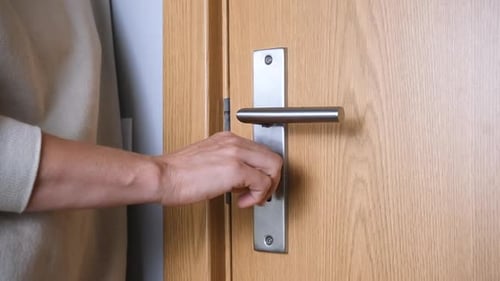 Close Up of a Woman Unlocking a Wooden Door with a Key Concept of Security Access Home Entrance