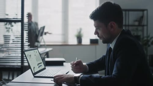 Man Analyzing Data at Office Workplace Computer