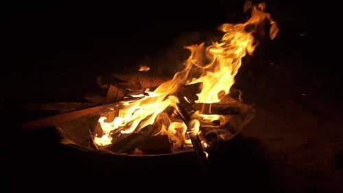 camera slow zoom in on camp fire flames with black background shot in slow motion