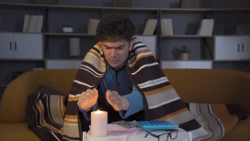 Worried Adult Counting Money by Candlelight Indoors