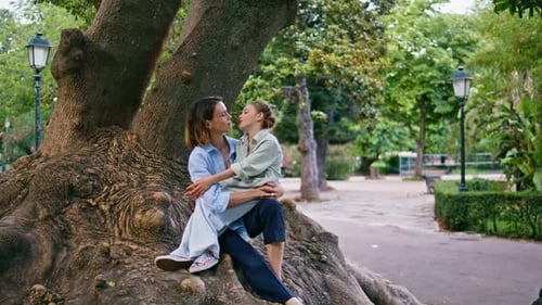 Woman and Child Embrace by Large Tree in Park