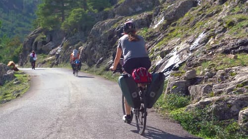 Andar en bicicleta por senderos pintorescos en terrenos montañosos con otros ciclistas