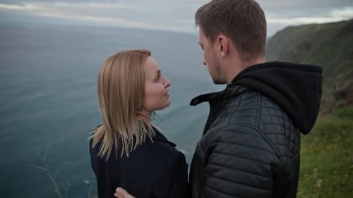 Romantic Couple Embracing on a Cliff Overlooking the Ocean