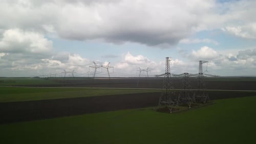 Aerial View of Power Lines Over Green Agricultural Field