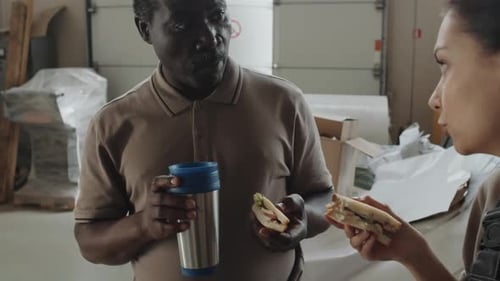 Workers Enjoying Lunch Break in a Warehouse Setting