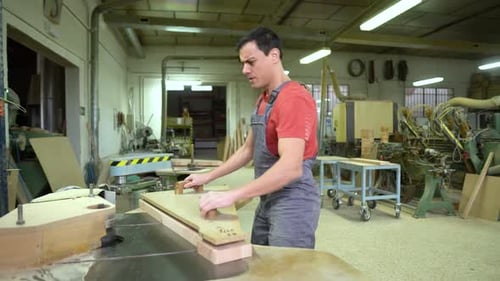Craftsman Using Woodworking Machine in Workshop