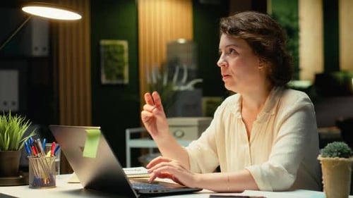 Woman working late at laptop in home office