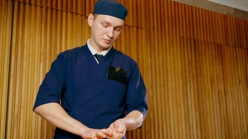 Closeup in Japanese Restaurant the Chef Lays Out Pieces of Raw Fish on a Plate