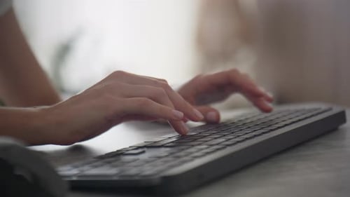 Woman Typing on Wireless Keyboard at Home