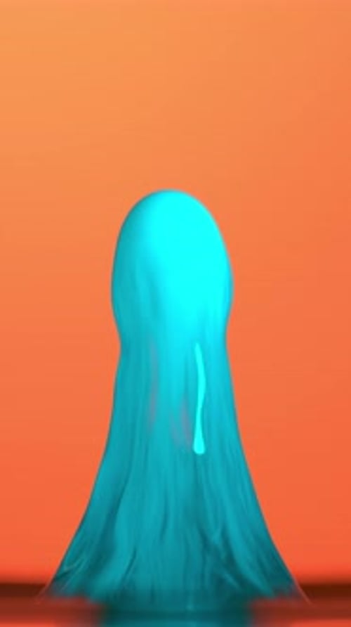 Blue Water Splash Against Bold Orange Backdrop In Slow Motion