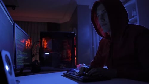 Background of male hacker using computer to commit crime.