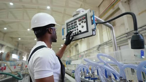 Black Operator Working at Programmable CNC Machine in Factory Industries