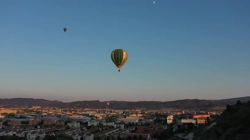 Hot Air Balloons Floating Over a City at Sunrise