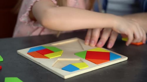 Child Plays with Colorful Geometric Puzzle Game with Adult