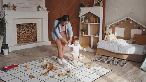 Woman Helps Baby Learn to Walk at Home