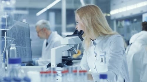 Scientist using microscope in modern research laboratory