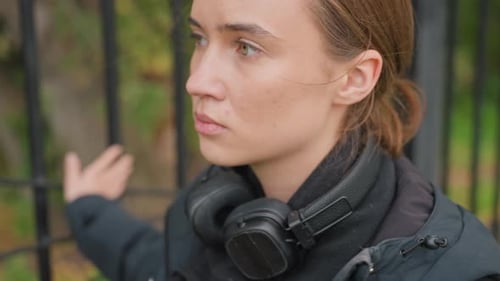 Woman with Headphones in Park She Listens and Reflects in Autumn Park Thoughtful Female Figure