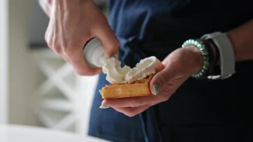 Girl Adding A Topping Whipped Cream On A Belgium Waffle Close Up