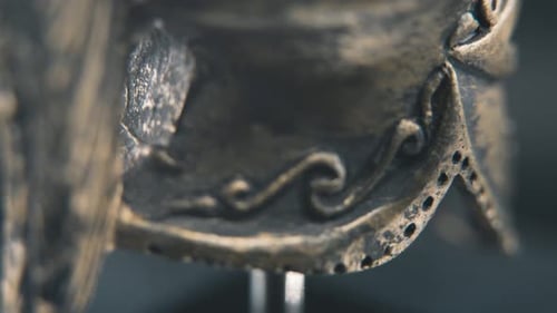 A close up detailed slow tilt up shot from behind of a spartan face design, warrior ancient greek br