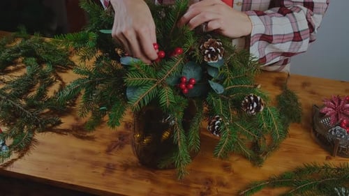 Woman Creating Christmas Centerpiece at Home