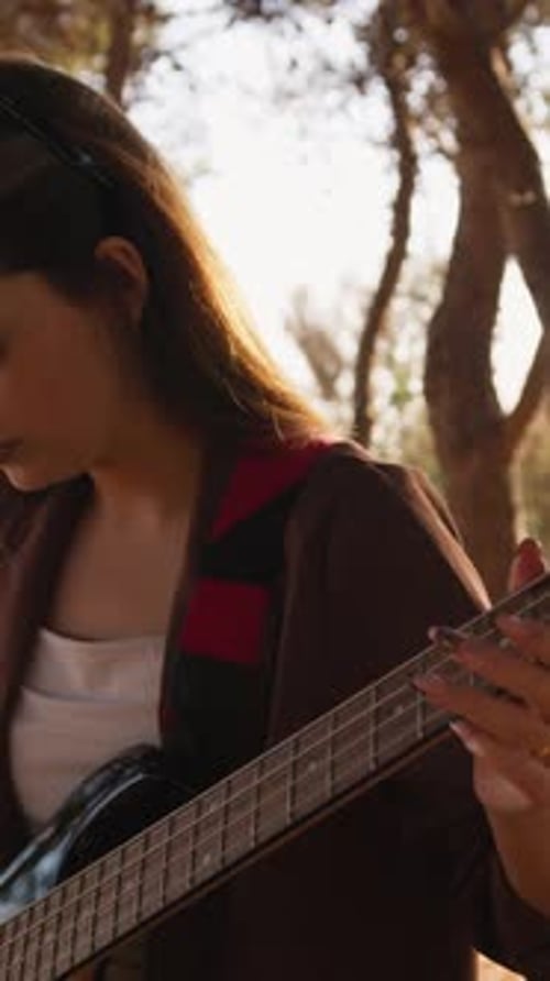 Woman Playing Bass Guitar Outdoors