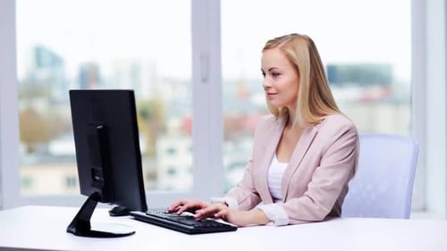 Young businesswoman working at computer typing in modern office workplace