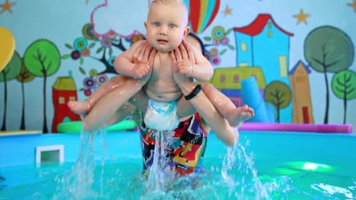 Woman Holding Baby in Swimming Pool