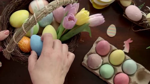 Colorful Easter Eggs being Placed in Decorative Nest