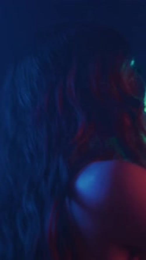 Smiling Woman Dances with Blue and Red Lighting