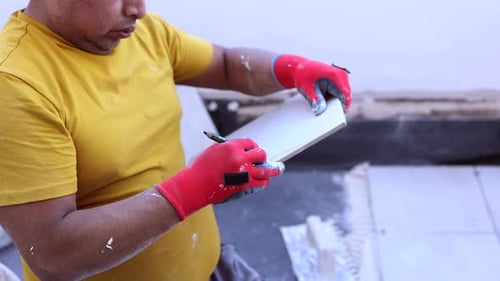 Man Marks Tile with Pencil Indoors