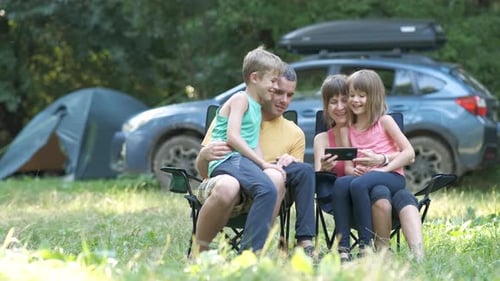 Family Camping Together, Looking at Cell Phone