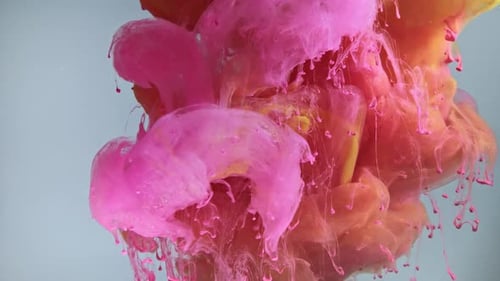 Colorful Nacreous Paint in Water Against Blue Background