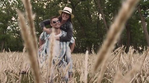 Piggyback. Casually Dressed Heterosexual In-Love Couple Having Fun Together In Field. Steadicam S...