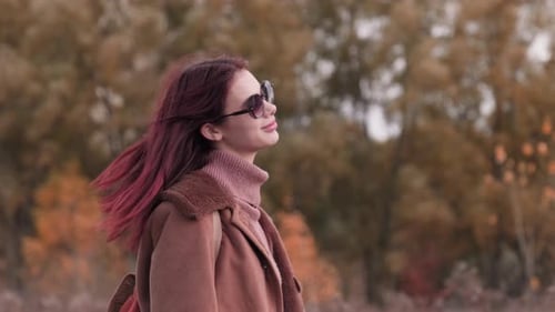 Fashionable Woman Poses in Autumn Foliage