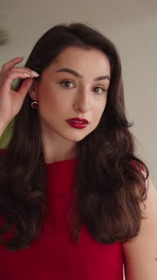 Femme élégante en robe rouge se préparant pour une occasion festive