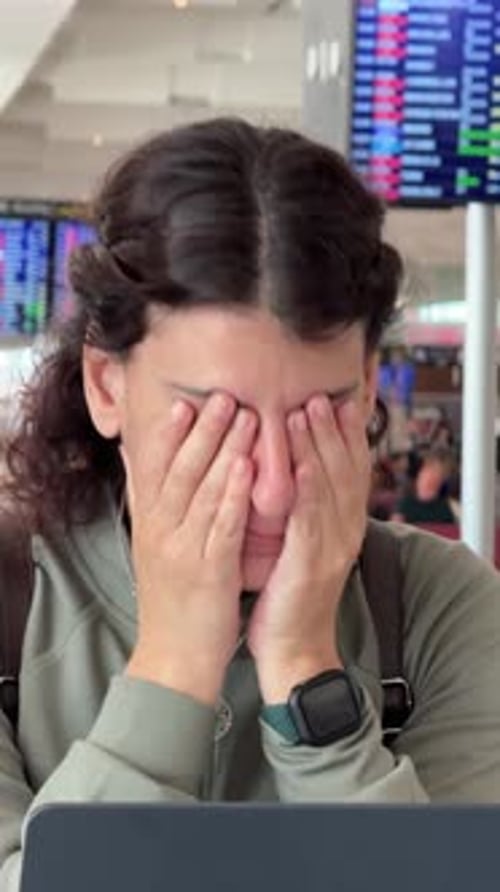 Stressed Tired Woman Waiting for a Delayed Flight in Airport