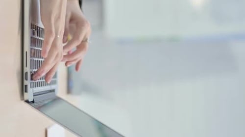 Woman Typing on Laptop in Bright Office Setting