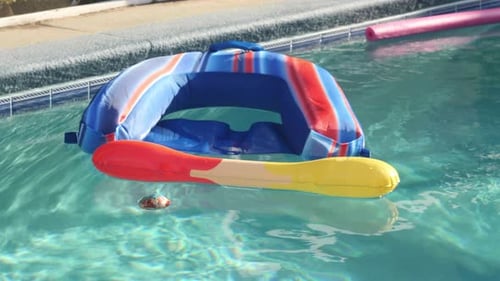 Pool Toys Float Around a Sunlit Swimming Pool in Slow Motion
