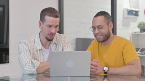Compañeros de equipo creativos hablando durante un chat de vídeo en línea en un ordenador portátil