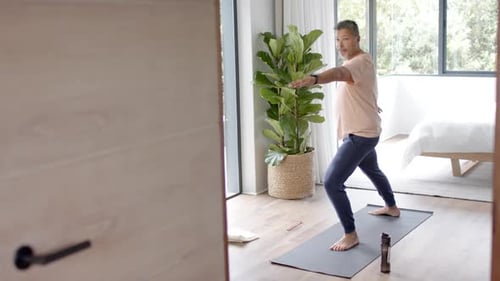 Adult Man Practices Yoga in Modern Bedroom