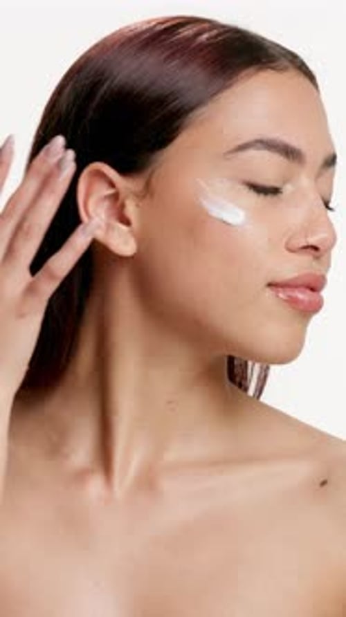 Beauty, woman and happy with face cream in studio for skincare routine, hydration and skin glow