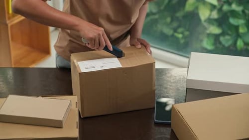 Woman Opens Box with Utility Knife in Office