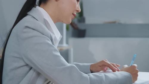 Portrait of Serious Business Woman Writting in Notebook Sit at Office Desk Focused Female Working in