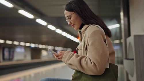Woman Using Smartphone While Waiting for Metro Train