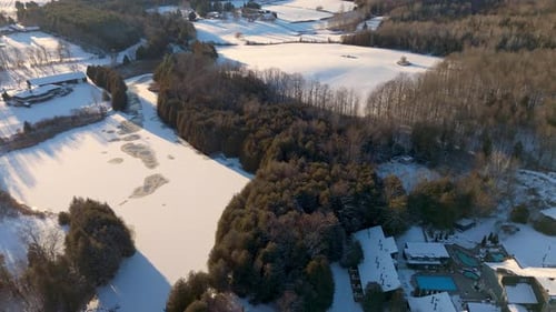 Serene Aerial View of Snow Covered Forest and Frozen Lake