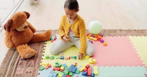 Girl child, building blocks and puzzle on floor, thinking or development for problem solving skills