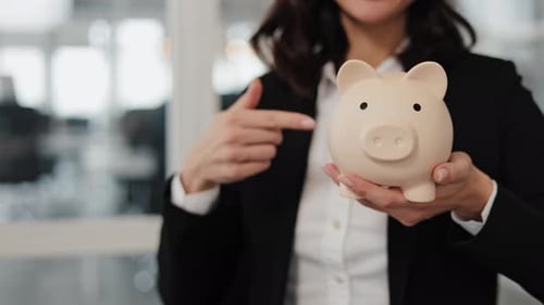 Businesswoman Holding Piggy Bank and Pointing to Copy Space