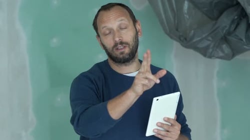 Man with Tablet Explains Home Improvement Project