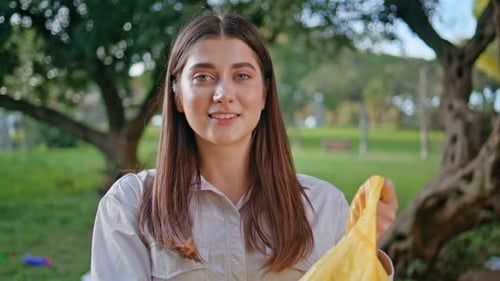 Mujer arroja una botella de plástico en una bolsa de reciclaje en Park Closeup Eco Volunteer